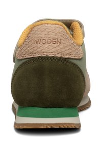 Sneaker med et multimaterialedesign med grønne, brune og gule accenter, tekstureret overdel og en polstret sål med en grøn stripe.