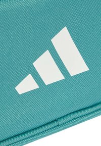 Funda de tela en color verde azulado con un diseño de logo blanco de tres rayas. Superficie texturizada con costuras reforzadas en los bordes.