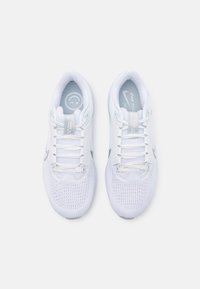 Par de zapatillas de running Nike blancas con partes superiores de malla, cordones y logotipos de swoosh grises, vistas desde arriba sobre un fondo blanco.