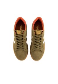 Zapatillas de montañés de ante verde oliva con rayas blancas. Presentan un interior naranja y una etiqueta de marca en la lengüeta. Suela de goma para mayor agarre.