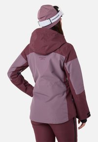 Giacca da sci bordeaux e lavanda con cappuccio, con maniche a contrasto, logo sul retro e tasche laterali con zip.