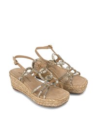 Sandali con zeppa beige con dettagli metallici a forma di anello, piattaforma in iuta testurizzata e cinturino alla caviglia regolabile. Materiale morbido simile al camoscio.