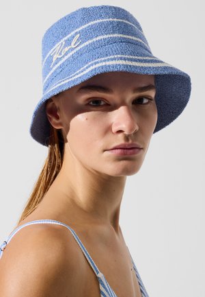 Blauwe emmerhoed gemaakt van gestructureerde stof met witte strepen. Voorzien van geborduurd logo aan de voorkant. De rand is licht uitlopend.