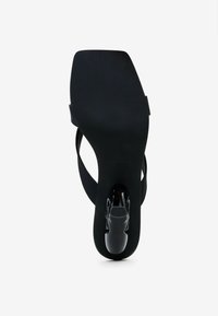Schwarze Absatzsandale mit offener Spitze, ausgestattet mit einer glatten Oberfläche, einer gepolsterten Innensohle und einem eleganten Rückriemen für Unterstützung und Stabilität.