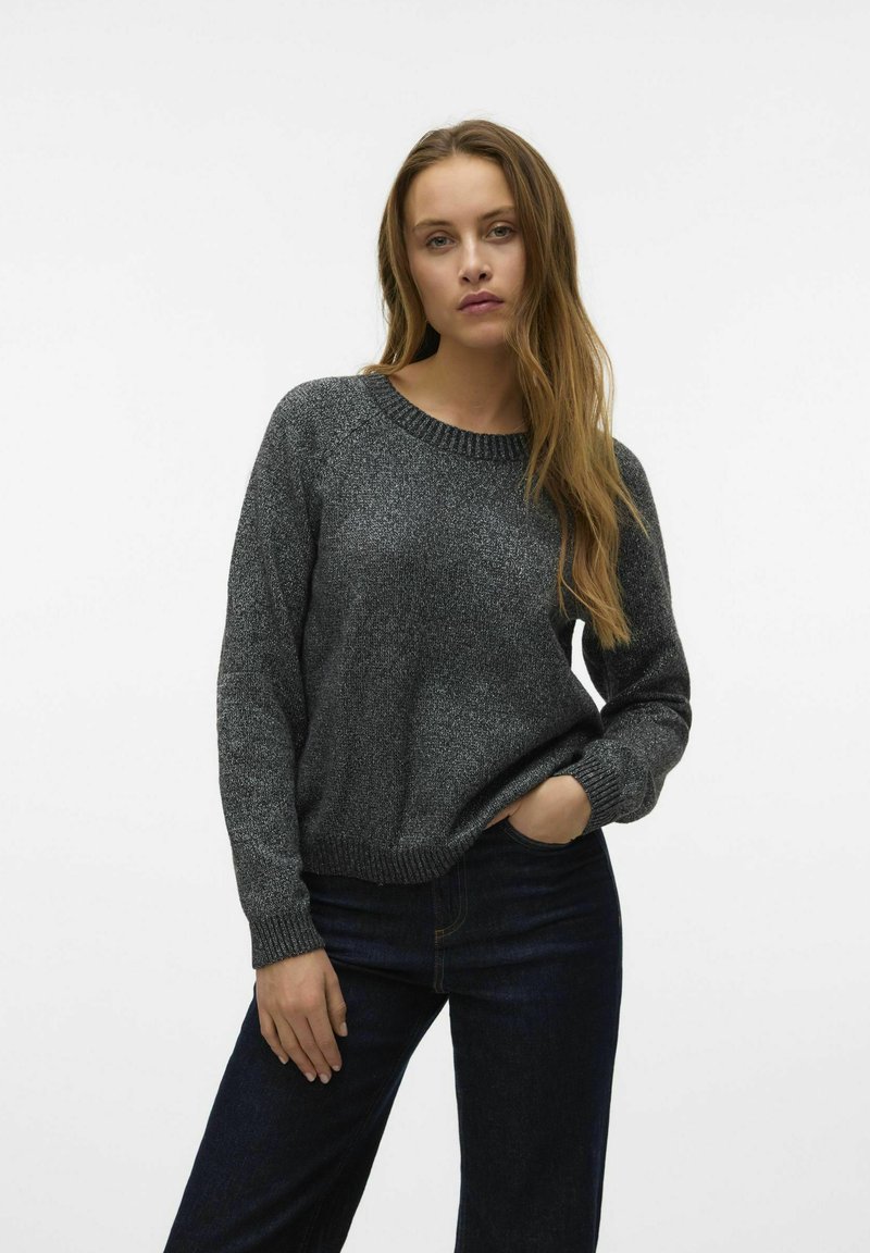 Maglione grigio lavorato a maglia con colletto arrotondato, polsini a coste e finitura texturizzata, abbinato a jeans in denim scuro.