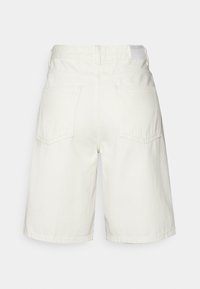 Shorts en denim blanc taille haute avec poches arrière, passants de ceinture et une petite étiquette de marque sur la taille.