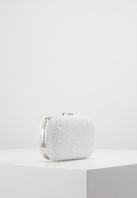 Clutch blanco de cuentas con forma rectangular, superficie texturizada y herrajes plateados. Presenta un diseño adornado con pequeñas perlas blancas.