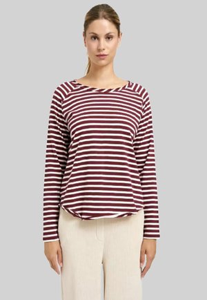 Langarmshirt mit kastanienbraunen und cremefarbenen Streifen, rundem Halsausschnitt, lässiger Passform und weichem Stoff. Kombiniert mit beigen, gerippten Hosen.