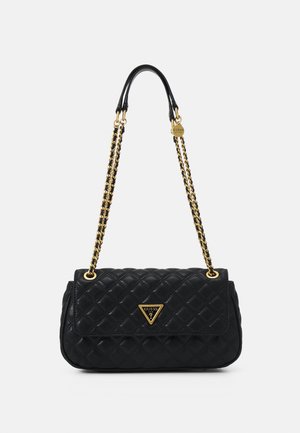 Sac à main matelassé noir avec une bandoulière chaîne dorée et une plaque triangulaire avec le logo Guess sur le rabat avant.