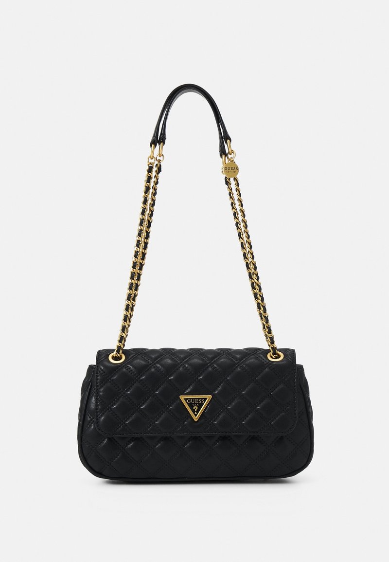 Sac à main matelassé noir avec une bandoulière chaîne dorée et une plaque triangulaire avec le logo Guess sur le rabat avant.