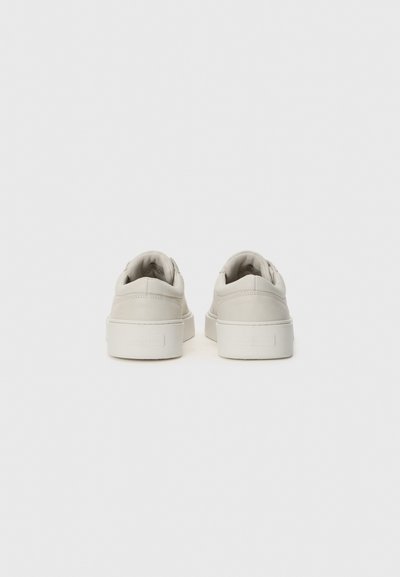 Light gray sneakers with a smooth leather upper, rounded toe, and flat rubber sole. Minimalist design with no visible branding.