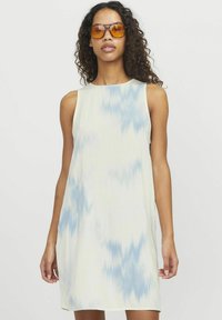 Ärmlös klänning i mjukt tyg med en krämfärgad botten och blå batikmönster, med en avslappnad passform och rund halsringning.