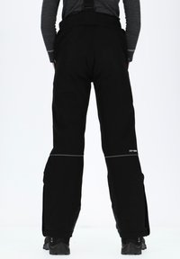 Pantalons de neige imperméables noirs avec bretelles réglables, zips sur les côtés et détails réfléchissants près de l'ourlet. Texture douce, tissu durable.