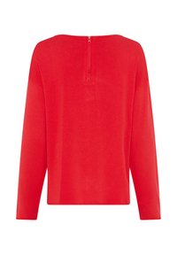 Maglia rossa a manica lunga con scollatura ampia, dotata di zip centrale sul retro e vestibilità rilassata. Tessuto liscio con texture minimale.