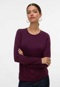 Lange mouw paarse shirt van zacht materiaal met een ronde hals, met een relaxte pasvorm en een lichte textuur. G gedragen met donkere spijkerbroek.