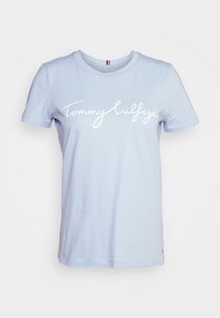 Jasnoniebieska bawełniana koszulka z krótkim rękawem, z białym, kursywnym logo "Tommy Hilfiger" na piersi oraz małym logo przy dolnym brzegu.