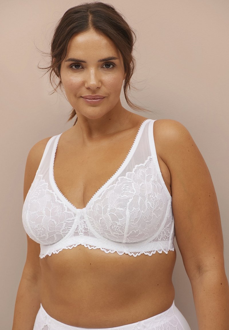 Witte kanten bralette met een bloemmotief, voorzien van brede bandjes en een V-halslijn. De textuur is zacht met een geschulpte randdetail.