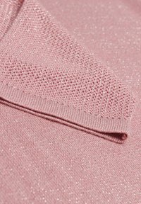 Rosa gestrickter Stoff mit einem strukturierten Muster und subtiler glänzender Oberfläche, versehen mit einem gerippten Rand und sanft gefaltetem Design.