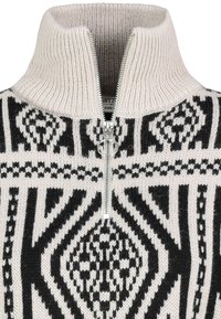 Handgestrickter Wollpullover mit hohem Kragen, der ein schwarzes und cremfarbenes geometrisches Muster sowie einen silbernen Reißverschluss am Hals aufweist.