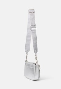Zilveren metallic schoudertas met een gestructureerde afwerking, verstelbare strap en zilveren hardware, uitgerust met een klein ritsvakje.