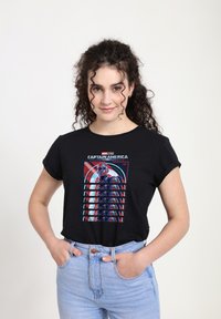 Camiseta de algodón negra con un estampado gráfico de Capitán América con un fondo de escudo rojo y blanco, de mangas cortas y ajuste relajado.