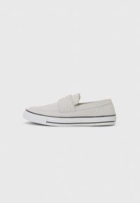 Lys grå slip-on sko laget av lerret, med rund tå, elastiske sidepaneler, hvit gummisol, og svart stripe detaljer.