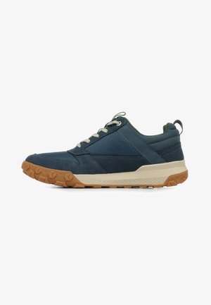 Scarpa sportiva blu navy con tomaia strutturata, punta rinforzata e suola in gomma beige. Presenta lacci grigi e un colletto imbottito per il massimo comfort.