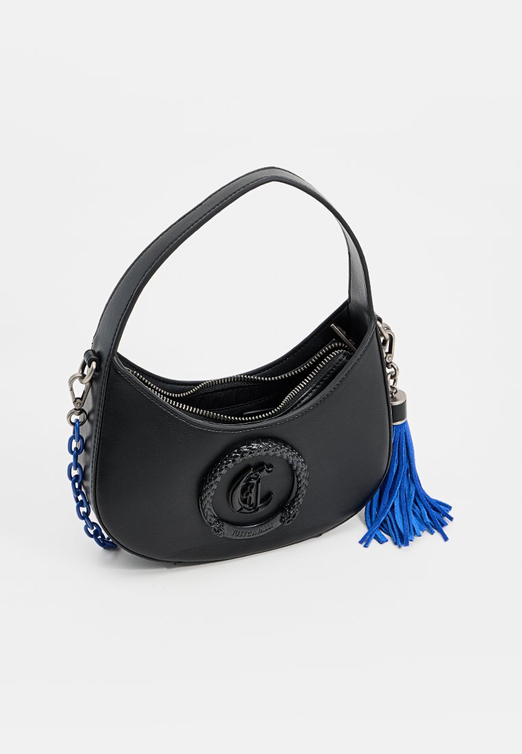 Sac à main en cuir noir avec une silhouette courbée, présentant un logo circulaire en texture tissée et un accent de pompon bleu sur une bandoulière en chaîne.