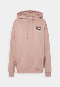 Felpa con cappuccio rosa polvere in tessuto morbido, con tasca a marsupio frontale, cappuccio con coulisse regolabile e grafica di una farfalla sul petto.