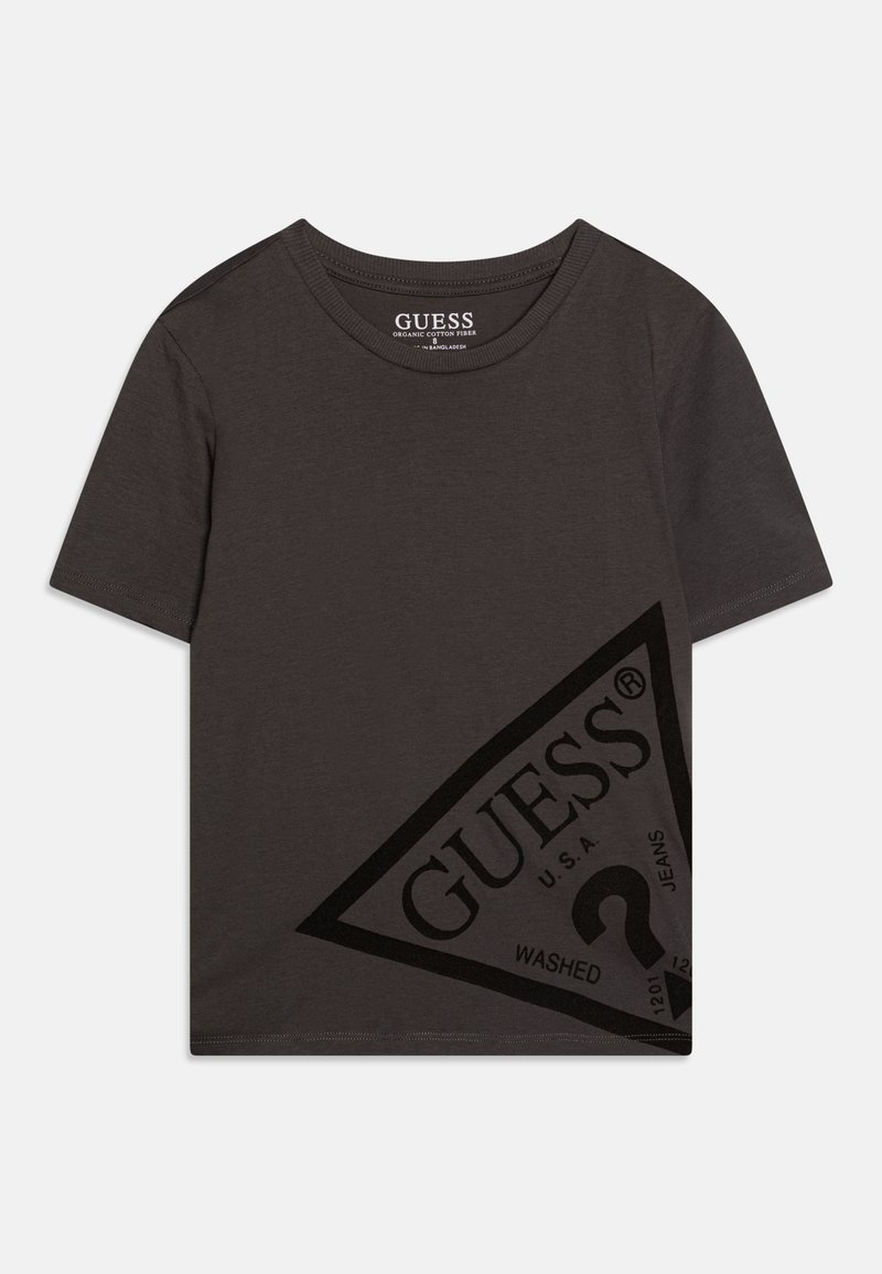 Kortermet, mørkegrå t-skjorte laget av økologisk bomull. Har et trekantet logodesign med "GUESS" og "WASHED" i svart trykk.