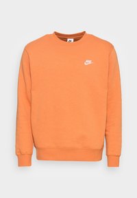 Sudadera naranja de algodón suave, con cuello redondo, mangas largas y un pequeño logo blanco de Nike en el pecho.