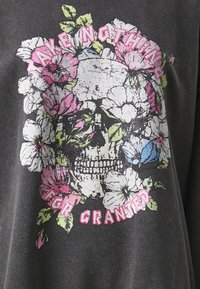 Graphic dark gray shirt featuring a skull surrounded by colorful flowers and the phrase "TAKE NOTHING FOR GRANTED" in pink text.