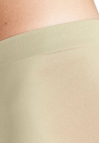 Leggings in verde oliva chiaro, con una cintura liscia e testurizzata e una sezione inferiore trasparente con un motivo sottile.