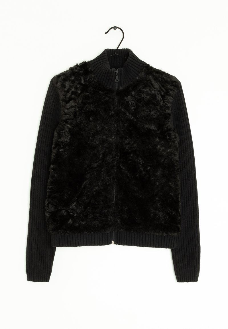 Schwarze Zip-Jacke mit einem Vorderteil aus Kunstfell und gerippten Strickärmeln. Der Kragen ist ebenfalls gerippt, um zusätzliche Textur zu bieten.