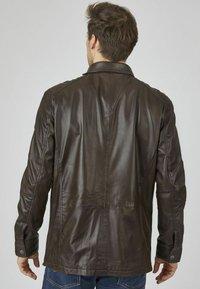 Braune Lederjacke mit glatter Textur, strukturiertem Design und Kragen; verfügt über Schulternähte und gefütterte Manschetten.