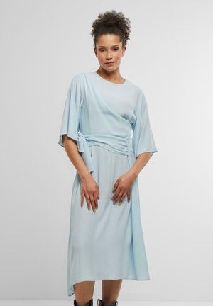 Hellblaues Wickelkleid mit Ellenbogen-langen Ärmeln, weicher Textur und einem geknoteten Gürtel-Detail an der Taille. Fließende Silhouette und Midi-Länge.