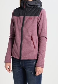 Kaptur z pikowanego czarnego materiału i górna część, burgundowe korpusu, zamek błyskawiczny z przodu, dwa boczne kieszenie z czerwonymi akcentami, wykonana z teksturowanej, elastycznej tkaniny.