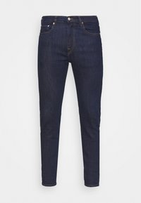 Tmavě modré džíny s úzkým střihem, pětiokovovým designem, viditelným šitím a zapínáním na knoflík a zip. Hladká textura.