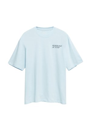 Jasnoniebieska koszulka z krótkim rękawem, okrągłym dekoltem i czarnym napisem "HOMMAGE AU SURF" na górnej lewej części klatki piersiowej.