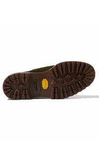 Suola di stivale in suede verde con una robusta suola in gomma marrone caratterizzata da profonde scanalature e un logo Vibram giallo. Il testo include i nomi del marchio e del modello.