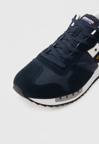 Αθλητικό παπούτσι σε ναυτικό μπλε και λευκό με πάνελ από σουέτ και δίχτυ, ναυτικό κορδόνια και ετικέτα με το λογότυπο "Blauer" στη γλώσσα.