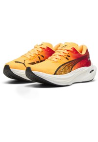 Des chaussures de course avec une tige en mesh présentant un dégradé d'orange à jaune, des accents noirs et une semelle blanche rembourrée.