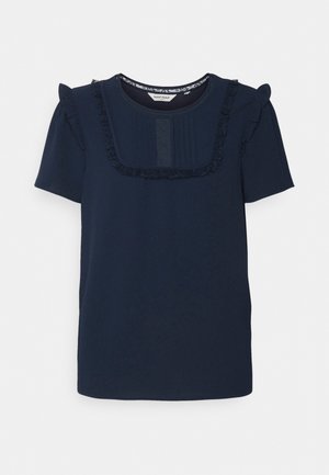 Top a maniche corte blu navy con spalline volantee, bordo in pizzo lungo il collo e pieghe verticali sul pannello centrale. Tessuto morbido.