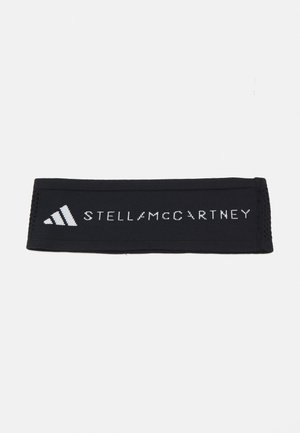 Svart stoffhodebånd med hvite Adidas- og Stella McCartney-logoer midt på en enkel hvit bakgrunn.