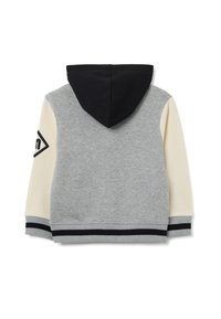 Giacca grigia con cappuccio nero, maniche crema e polsini a costine. Presenta un logo nero e un design del bordo a contrasto.