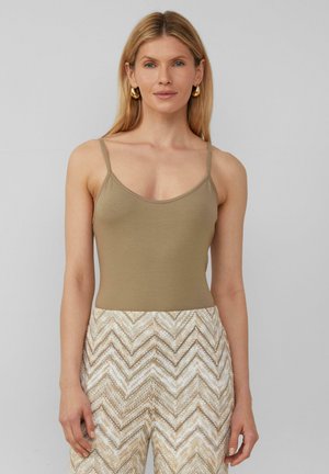 Tan getailleerd tanktop met dunne schouderbandjes, gemaakt van zachte stof. Gecombineerd met crèmekleurige en beige hoog-waisted broek met zigzagpatroon.