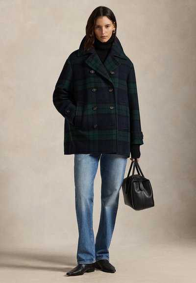 Kahekordse lõikega ruuduline mantel mereväe- ja rohelisest villast, suurte krae, nööpidega ja kahe küljetaskuga. Sobitatud heledate teksade ja musta kotiga.