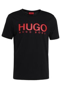 Svart bomullströja med fet röd "HUGO"-text och "HUGO BOSS" i mindre bokstäver under. Klassisk rundhalsad design.