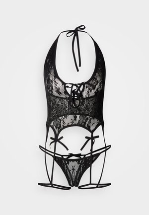 Črno čipkasto spodnje perilo s halter ovratnikom, z zvezenimi pasovi in prosojno teksturo, ki poudarja zapletene vzorce in zavezovanja.