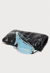 Lunettes de sport transparentes bleues au design épuré, accompagnées d'un étui noir rembourré avec une inscription en texte blanc.